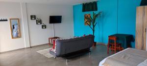 - un salon avec un canapé et un mur bleu dans l'établissement appartement Villa Nancy, à Toamasina