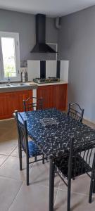 a table and chairs in a kitchen with a table and a stove at appartement Villa Nancy in Toamasina