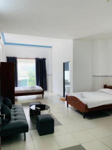 sala de estar con 2 camas y sofá en HomeStay KV2 en Bình Thủy