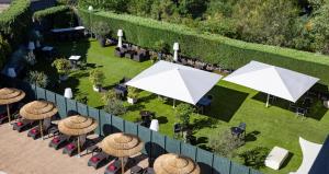 einen Blick über einen Garten mit Tischen und Sonnenschirmen in der Unterkunft Hotel Nuevo Boston in Madrid