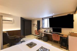 a room with a desk and a large screen television at STAY201 in Jecheon
