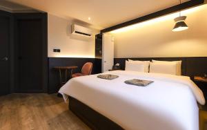 a hotel room with a large white bed and a table at STAY201 in Jecheon