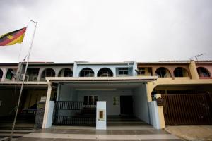 un edificio con una bandiera che batte di fronte ad esso di Hom2rex Kuching Homestay Taman Timberland a Kuching