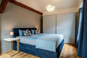 a bedroom with a blue bed and a chandelier at Ferienwohnung Heinrich und Rosa in Naumburg Saale in Naumburg