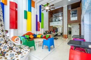 a living room with colorful chairs and a table at The Color Kata in Kata Beach