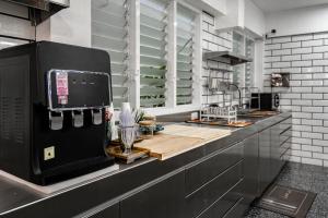 a kitchen with a black refrigerator and a counter at The Color Kata in Kata Beach