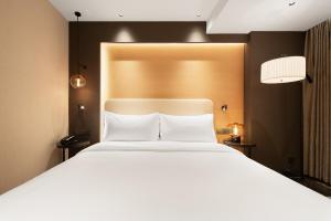 Rúm í herbergi á Langham Honor International Hotel Canton Fair Complex Branch - Free Shuttle to Canton Fair Complex During Canton Fair Period & Free Mini Bar