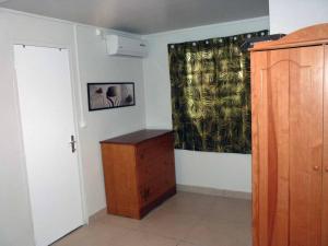 a room with a dresser and a wall with a curtain at Logement dans un lieu calme et verdoyant à proximité de tout avec Jacuzzi!!! in Basse-Terre