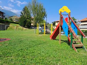 a playground with a bunch of playground equipment in a field at Appartamento La terrazza di Dora in Menaggio