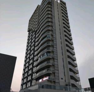 un edificio de apartamentos alto con muchas ventanas en Qingdao Shuiyunjian Apartment en Qingdao