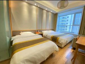 a hotel room with two beds and a window at Qingdao Shuiyunjian Apartment in Qingdao