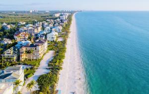 an aerial view of a beach with houses and the ocean at Stunning 2 BR w/ private patio in perfect location in Bonita Springs