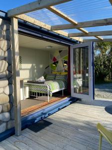 un patio con una cama en una terraza en Ross Beach TOP10 Holiday Park, en Ross