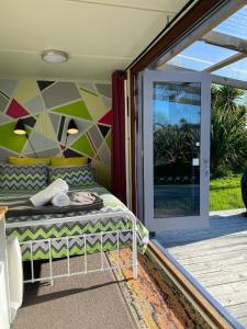 a bedroom with a bed next to a sliding glass door at Ross Beach TOP10 Holiday Park in Ross