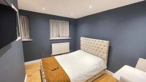 a bedroom with a bed and a blue wall at Apartment & Rooms in London in Croydon
