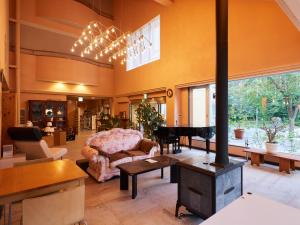 a living room with a fireplace and a stove at Asama Kogen Hotel in Tsumagoi