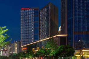 um grupo de edifícios altos em uma cidade à noite em Sheraton Nanchang Hotel em Nanchang