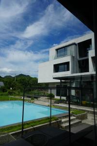 a building with a swimming pool in front of it at Tingting Lingshanjiang Light Luxury Art Homestay in Longyou