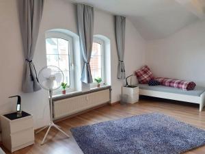 een slaapkamer met 2 ramen en een bed en een blauw tapijt bij Spacious Apartment for Traveler and Fitter in Lollar