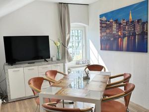 a dining room with a table with chairs and a tv at Spacious Apartment for Traveler and Fitter in Lollar