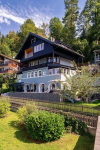a large blue and white house with a fence at Alpin Kanker Suites 1 in Garmisch-Partenkirchen