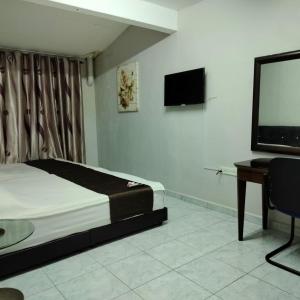 a bedroom with a bed and a flat screen tv at Persona Boutique Hotel in Melaka