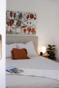 a bedroom with a white bed with a picture on the wall at Seascape Retreat: Time to Slow Down in Agnes Water