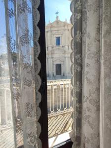 ein Fenster mit Blick auf ein Gebäude in der Unterkunft Yhomisus in Comiso