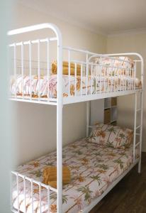 two bunk beds in a room with a bed at Seascape Retreat: Time to Slow Down in Agnes Water