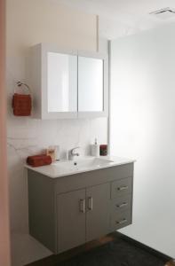 La salle de bains est pourvue d'un lavabo blanc et d'un miroir. dans l'établissement Seascape Retreat - Time to Slow Down - Suits Couples or Family with Kids with 2 sleeping spaces, à Agnes Water