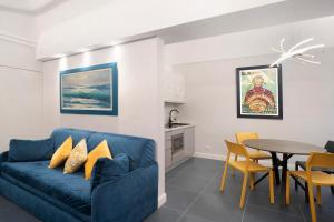 een woonkamer met een blauwe bank en een tafel bij Loft 42 in Alassio