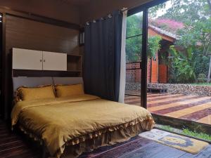 a bedroom with a bed and a large sliding glass door at Mana-An Lake Hill Resort in Chiang Mai