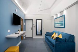 a living room with a blue couch and a tv at Loft 42 in Alassio