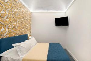 een slaapkamer met een bed en een tv aan de muur bij Loft 42 in Alassio