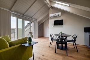 ein Wohnzimmer mit einer grünen Couch und einem Tisch in der Unterkunft Casa Calleri in Briaglia