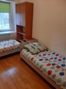 um quarto com 2 camas e um armário em Фэмили хостел em Almaty