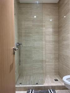 a bathroom with a shower with a toilet and a glass door at prestigia accès auto f3 vue imprenable pas fissure in Marrakesh