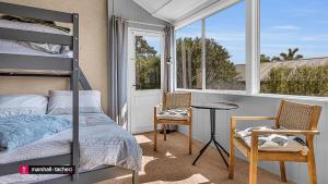 a bedroom with a bunk bed and a table and chairs at Bermagui Breeze Holiday House 5 bedroom 18-20 Mumbulla Street - Bermagui in Bermagui