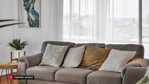 a couch with pillows on it in a living room at Bermagui Breeze Holiday House 5 bedroom 18-20 Mumbulla Street - Bermagui in Bermagui