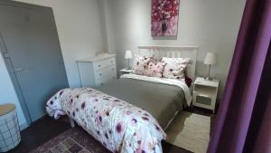 ein kleines Schlafzimmer mit einem Bett mit rosa Kissen in der Unterkunft Maison Barossa Issigeac in Issigeac