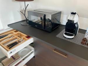 un bancone nero con forno a microonde e macchinetta del caffè. di Appartement cosy vue sur le vignoble a Sancerre