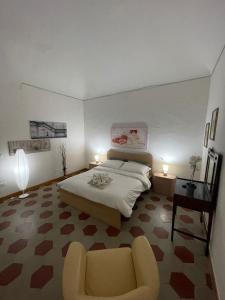 a bedroom with a bed and a chair and a table at Casetta 1870 in Ortona