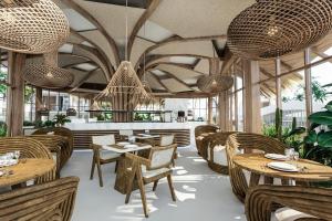a restaurant with tables and chairs and chandeliers at club arona by laren hotels in Serik