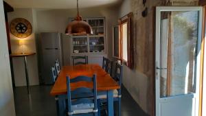eine Küche mit einem Tisch und Stühlen sowie einem Kühlschrank in der Unterkunft Maison Barossa Issigeac in Issigeac