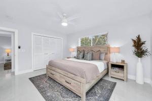 um quarto com uma cama e uma mesa com uma planta em Luxury Designer Delray Beach. 10 Min to the Beach! em Delray Beach