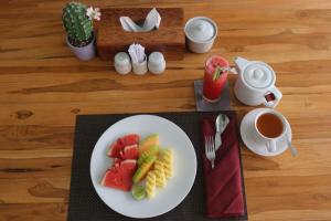 une assiette de fruits sur une table avec une tasse de café dans l'établissement BALE DATU BUNGALLOW, à Gili Trawangan