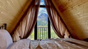 a bedroom with a bed with a view of a mountain at Magic Hut_Kazbegi in Kazbegi