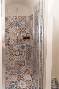 a bathroom with a shower with colorful tiles at LA CURT guest house in Artogne