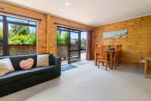 a living room with a couch and a table at Ngongotaha Lakeside Lodge in Ngongotaha