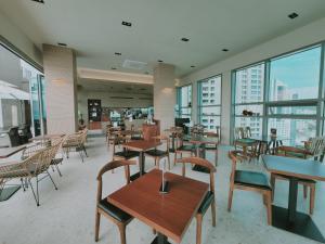 a restaurant with tables and chairs and windows at Best Travel in Haeundae with best location in Busan